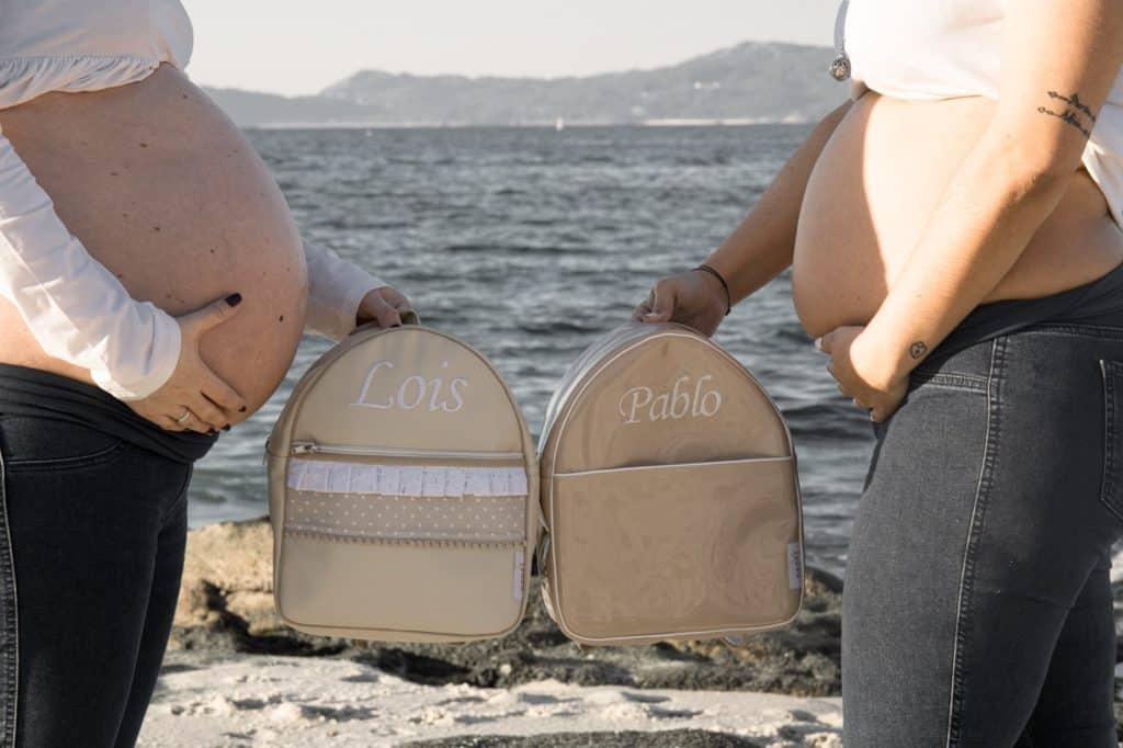 madres embarazadas enseñando mochilas de sus bebés personalizadas